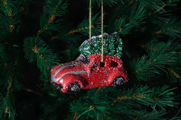 Boże Narodzenie zabawki czerwony samochód na drzewie Nowego Roku. Kompozycja świąteczna. — Zdjęcie stockowe