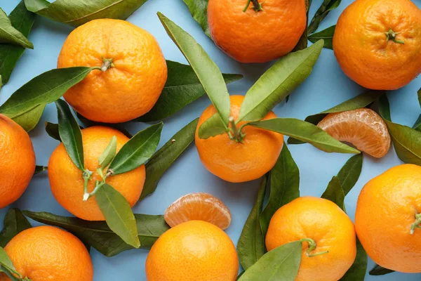 Mavi arka planda taze portakal mandalinaları. Düz yatıyordu.