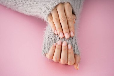 Pembe arka planda güzel manikürlü genç bir kızın güzel elleri. Kış bakımı, cilt, Spa konsepti