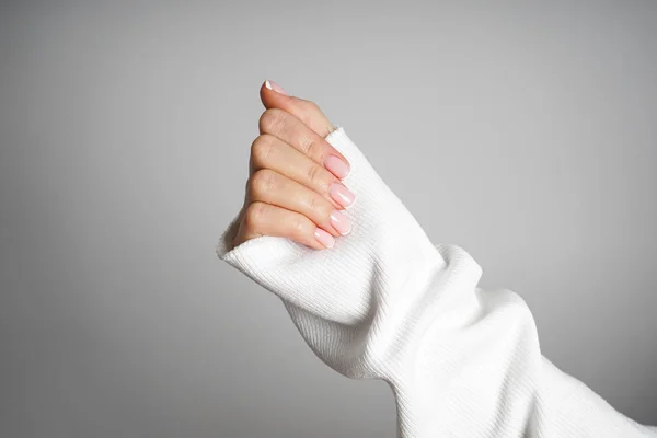 Winter care, skin, spa concept. Beautiful hand of a young girl with beautiful manicure on a gray background. — ストック写真