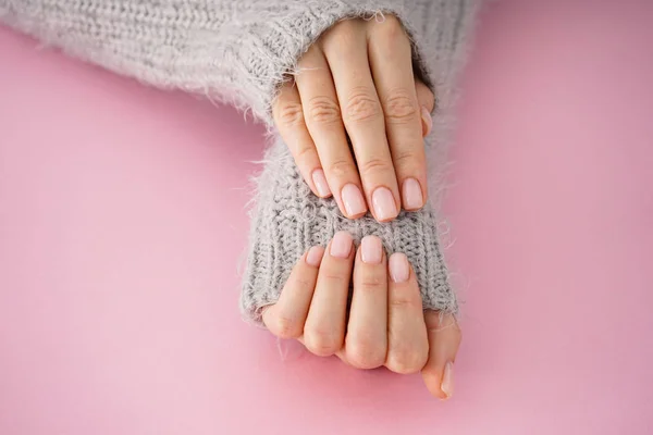 Beautiful hands of a young girl with beautiful manicure on a pink background, flat lay. Winter care, skin, Spa concept — ストック写真