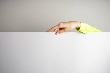 Güzel Fransız manikürü. Parlak bluzlu, gri arka planda mesaj için yeri olan genç bir kadının eli. Spa ve Manikür kavramı.