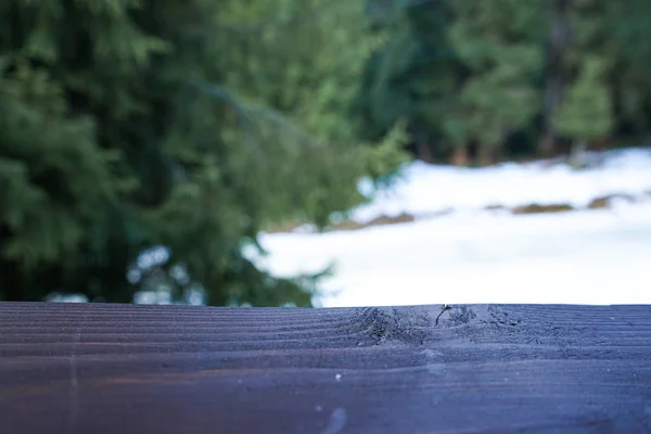 Tablero de madera sobre un fondo de un bosque con nieve, espacio para texto . — Foto de Stock