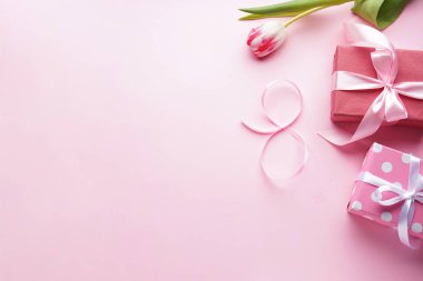 Düz sekiz adet pembe kurdele, güzel bir lale ve pembe arka planda hediyeler. Mesaj için yer var. 8 Mart, Uluslararası Kadınlar Günü.