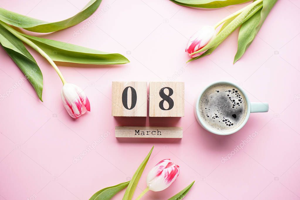 Beautiful tulips with a wooden calendar and a cup of coffee on a pink background, March 8. International Women's Day.