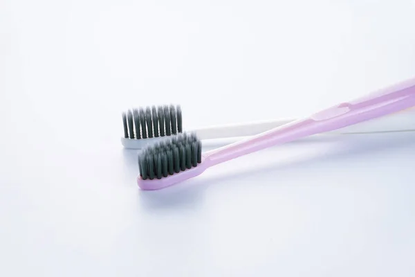 Two Beautiful Multi Colored Toothbrushes Black Shields White Background Close — Stock Photo, Image