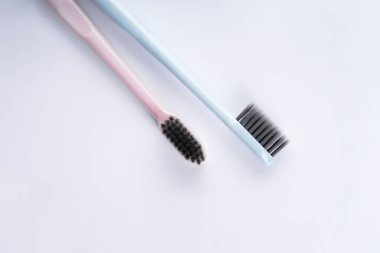 Beyaz kürdanlı pembe diş fırçası ve beyaz arka planda diş ipi..