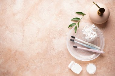 Bej arkaplanda çok renkli diş fırçaları ve metin için yer var. Hijyen ürünleri. 