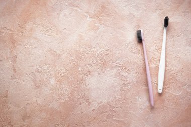 Düz konum iki çok renkli diş fırçası ile bej arkaplan üzerinde siyah tüyler metin için yer ile birlikte yatıyordu