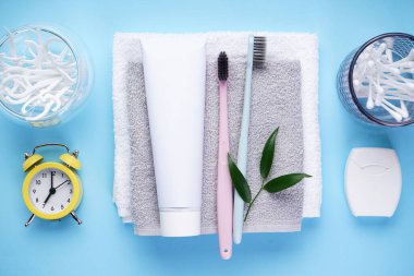 Sabah konsepti, mavi arka planda havluyla yakın plan diş fırçaları. Düz konum.