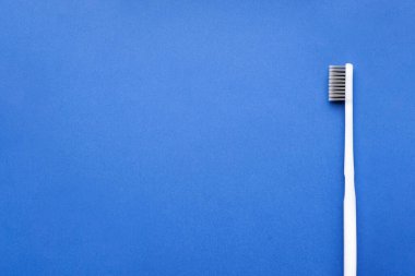 Mavi zemin üzerinde beyaz diş fırçası metin için boşluk, düz yatıyordu.