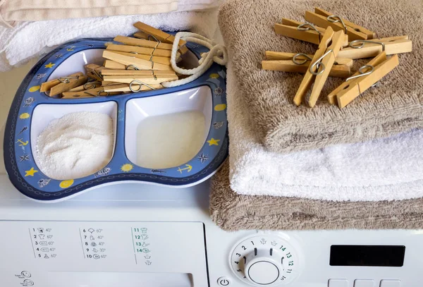 На стиральной машине чистые полотенца, прищепки и моющие средства . — стоковое фото
