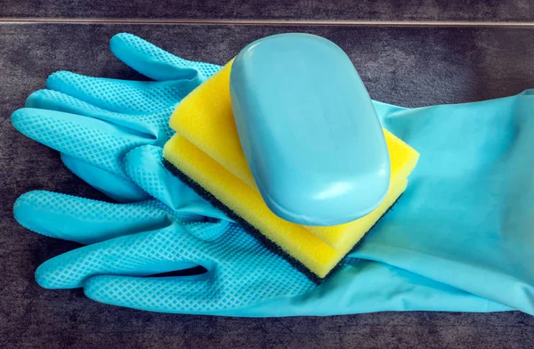 Rubber gloves and cellulose sponges ready for household cleaning tasks.