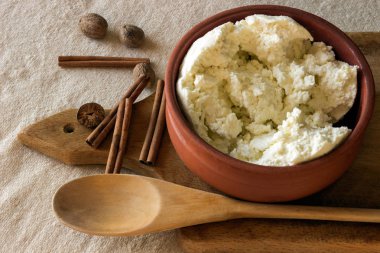 Bir seramik kase taze peynir. Tarçın ve Hindistan cevizi. 