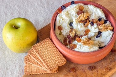 Kuru üzüm ve fındık bir seramik kase ile taze peynir. 