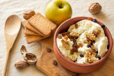 Kuru üzüm ve fındık bir seramik kase ile taze peynir. 