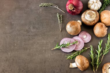 Taze mantar, soğan ve siyah bir arka plan üzerinde otlar. 