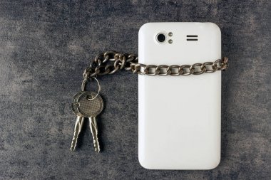 Modern cep telefonu ve anahtarları olan bir zincir.