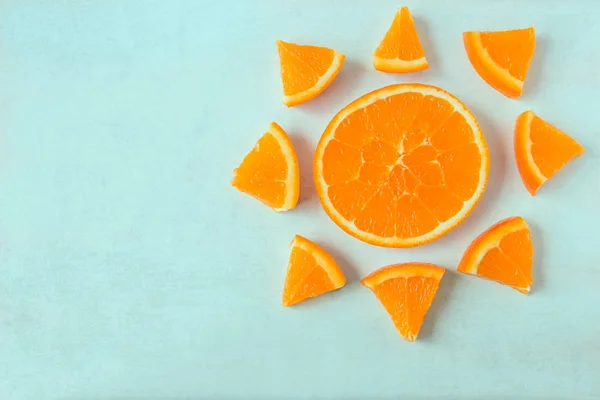 Helle saftige Orangenscheiben in Form einer Sonne auf hellem Hintergrund. — Stockfoto