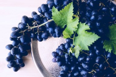 Bir gümüş tepsi üzerinde siyah üzüm. Yaz. 