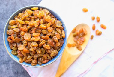 Mavi kase kuru üzüm. Tahta kaşık. 