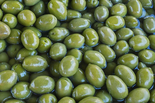 Groene heerlijk gemarineerde olijven. Achtergrond. Textuur. — Stockfoto