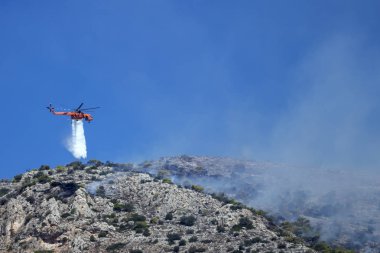 Yangın helikopteri yamaca yangın söndürür .  
