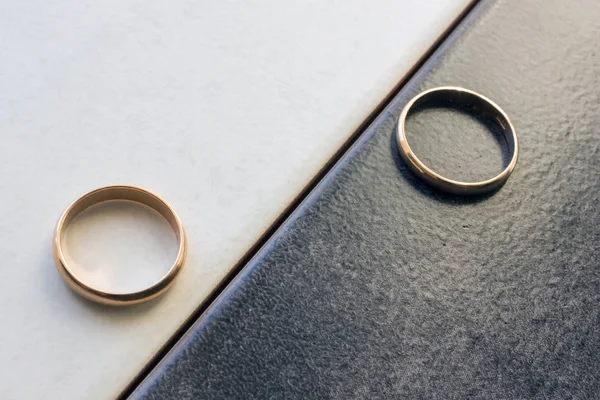 Dos anillos de boda separados sobre un fondo blanco y negro . — Foto de Stock