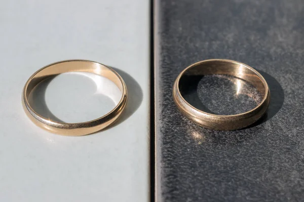 Dos anillos de boda separados sobre un fondo blanco y negro . — Foto de Stock