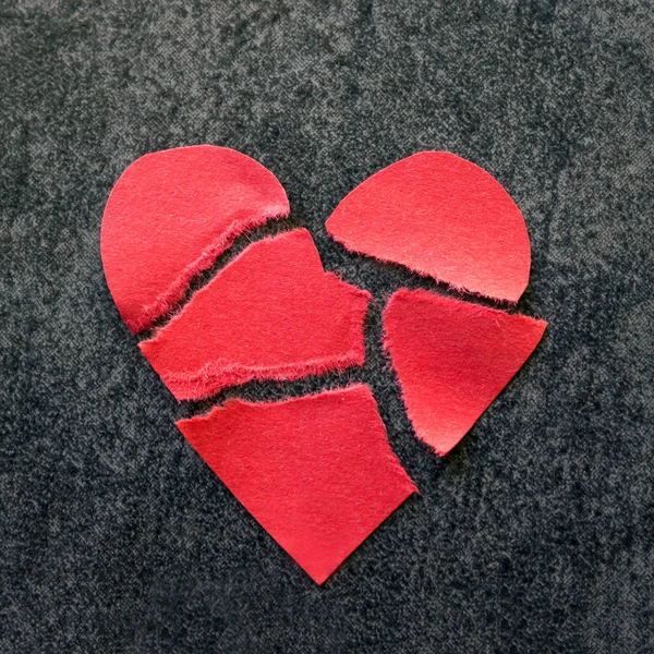 Corazón roto de papel rojo. Fondo negro . — Foto de Stock