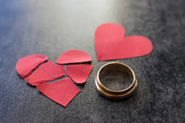 Anillos de boda y corazón rojo roto. Fondo negro . — Foto de Stock