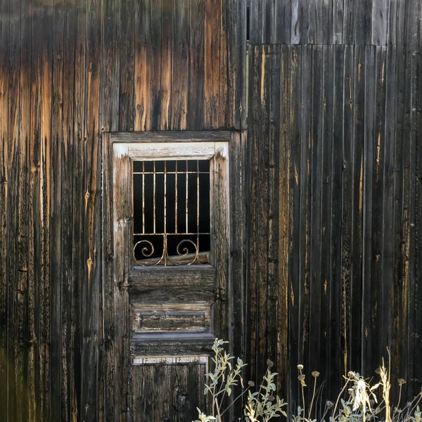 Velho cascalho. Porta de madeira com uma treliça . — Fotografia de Stock