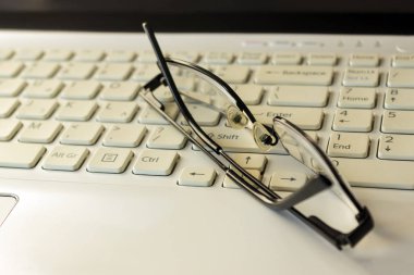 Laptop klavye, kalem ve siyah gözlük. İş kavramı. 