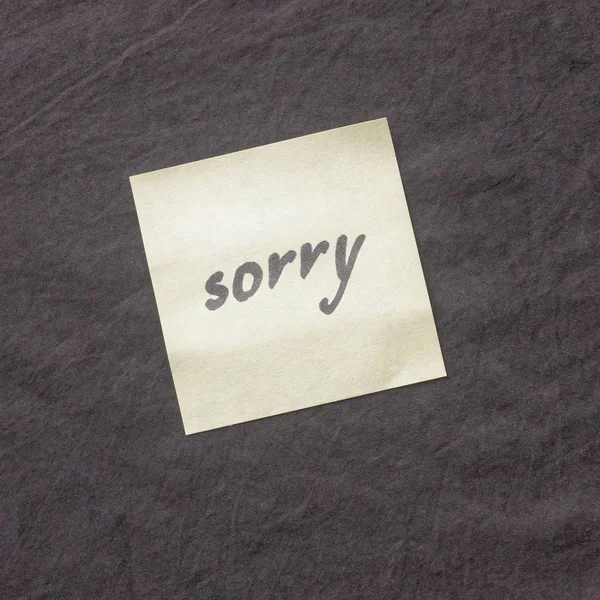 Χειρόγραφο σημείωμα σε σκούρο φόντο. Σημείωση του απολογία-Συγνώμη — Φωτογραφία Αρχείου