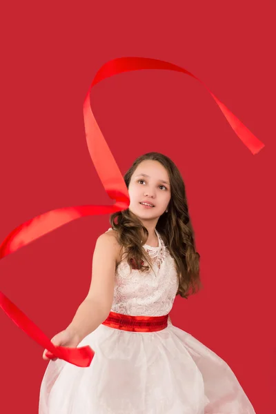 Дівчина-підліток кидає стрічку, ізольована на червоному — стокове фото