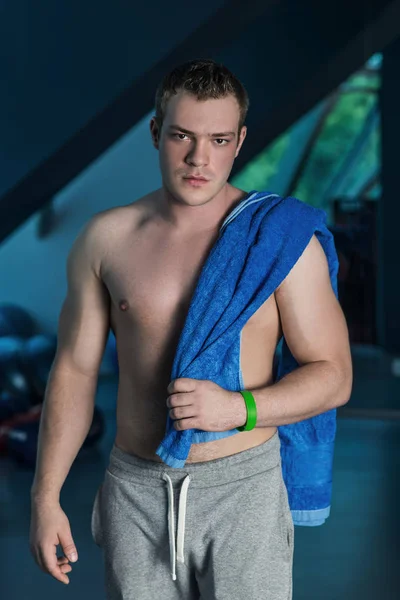 Portrait of handsome fitness man with naked torso, with towel