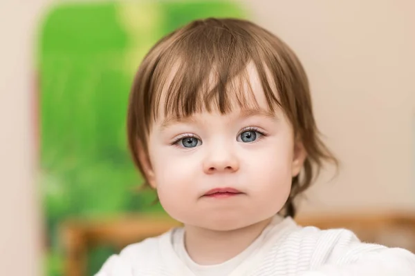 Portrait of adorable baby girl with blue eyes, indoors Royalty Free Stock Photos