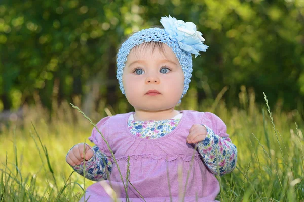 Doğa Park yeşil çimlerde oturan kız bebek