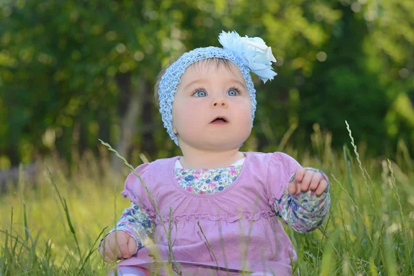 Doğa Park yeşil çimlerde oturan kız bebek