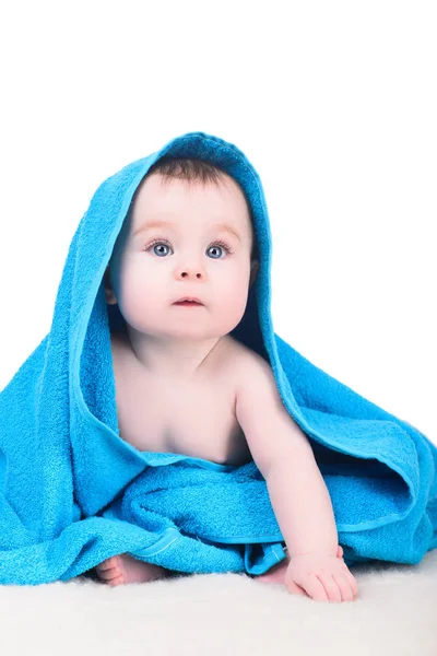 Bebê com grandes olhos azuis sentados no cobertor sob toalha — Fotografia de Stock