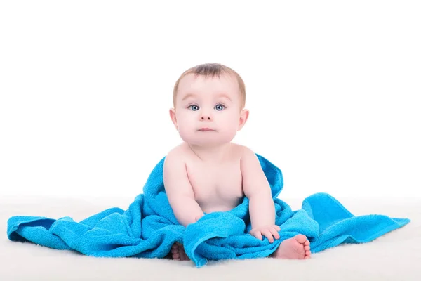 담요에 앉아 큰 파란 눈을 가진 아기 파란색 t에 싸여 — 스톡 사진