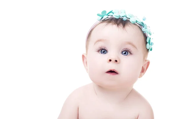 Portrait de bébé fille mignonne avec bandeau de fleurs sur sa tête — Photo