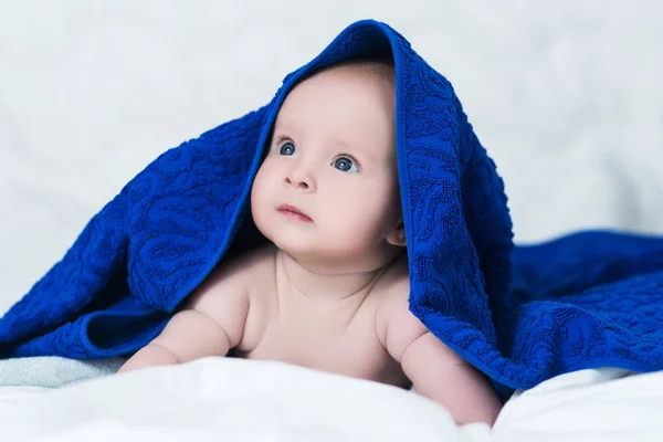 Cute baby after shower with blue towel on head — Stock Photo, Image