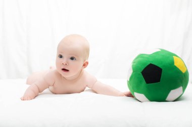 bebek erkek ya da kız karnı üzerinde uzanmış ve futbol oynamak