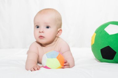 bebek erkek ya da kız karnı üzerinde uzanmış ve futbol oynamak