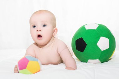 bebek erkek ya da kız karnı üzerinde uzanmış ve futbol oynamak