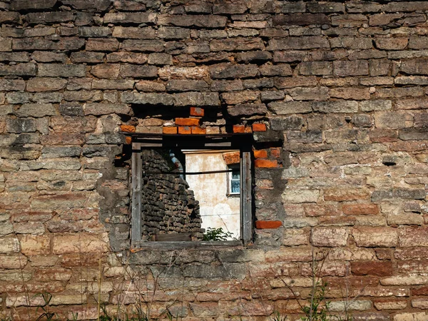 Parede de tijolo velho de um edifício arruinado com uma janela — Fotografia de Stock