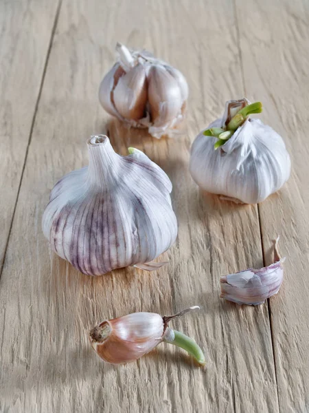Garlic with garlic cloves lies on a wooden background
