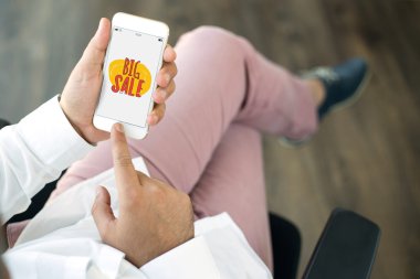 Erkek eller akıllı telefonu tutuyor.