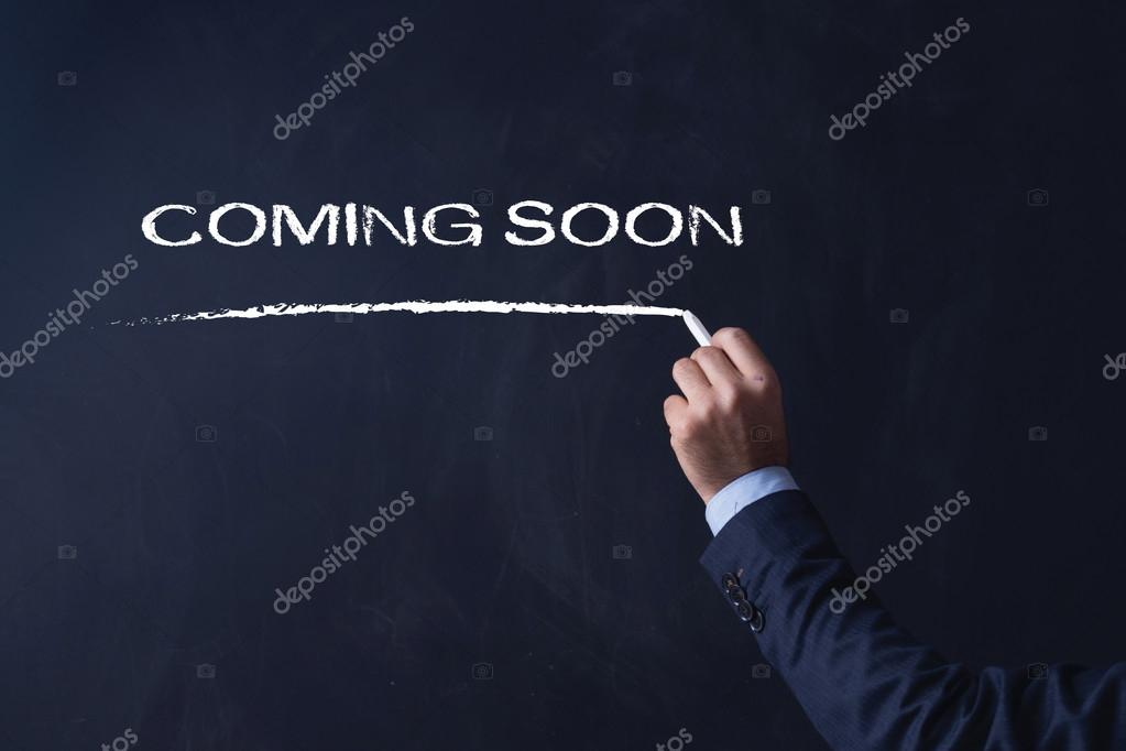 Businessman writing COMING SOON on Blackboard
